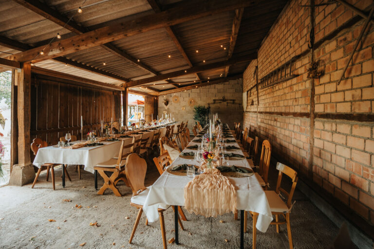Dekorierte Hochzeitstafel in rustikaler Scheune mit Lichterkette – Eventlocation Lindenhof Worblingen