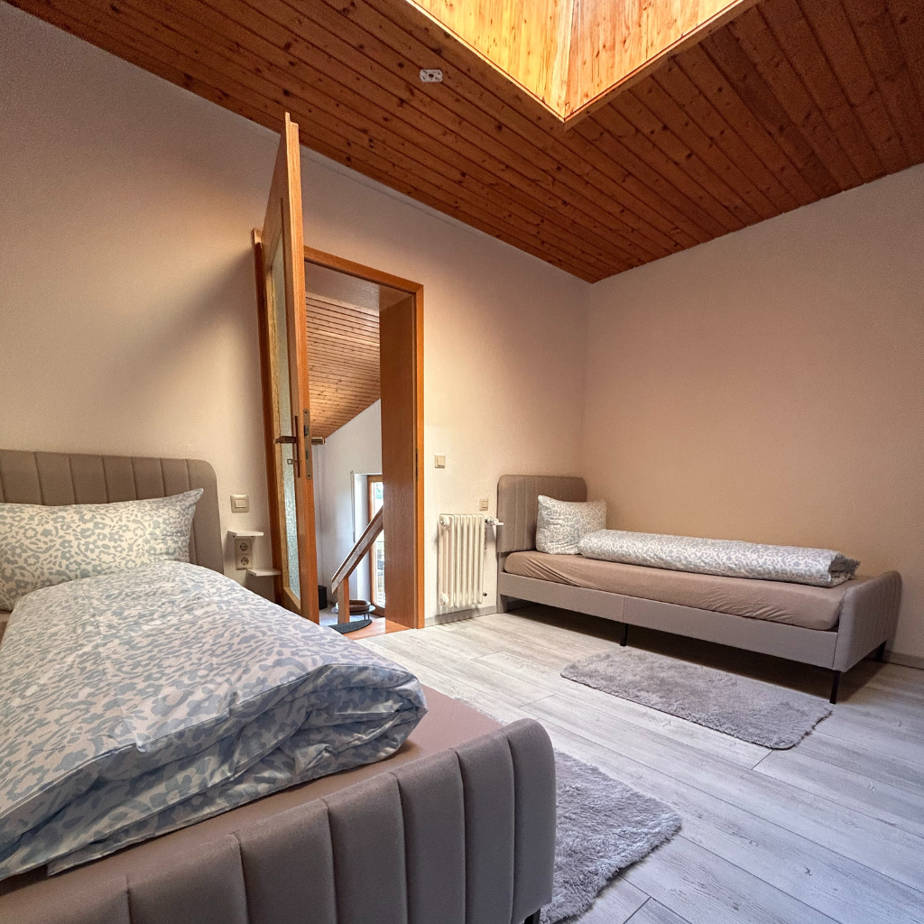 Schlafzimmer der Ferienwohnung 1 im Lindenhof Worblingen mit zwei Einzelbetten unter Dachschräge