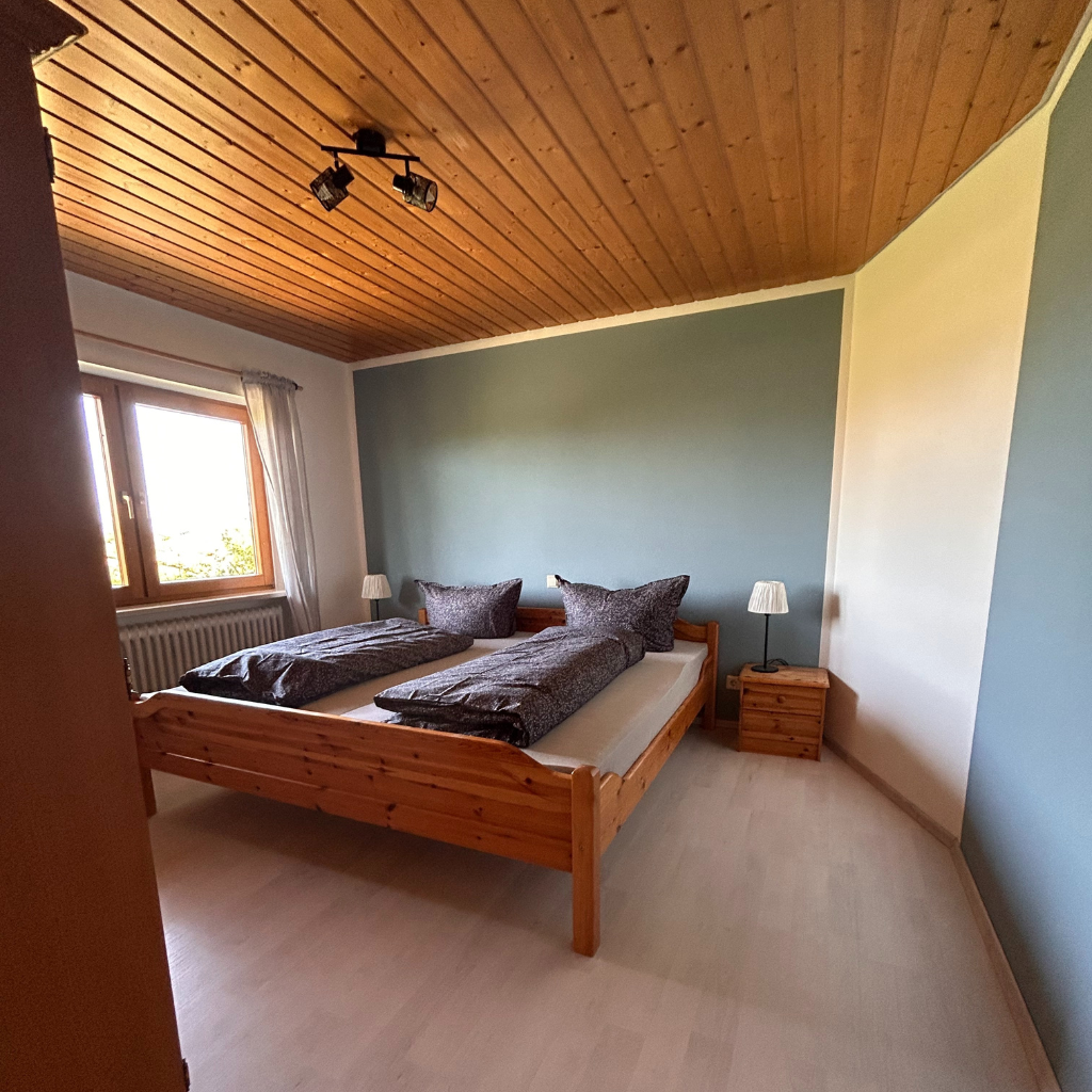 Schlafzimmer der Ferienwohnung 2 im Lindenhof Worblingen mit Doppelbett und Blick ins Grüne